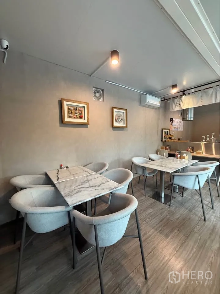 Retail Space for rent in Watthana, Bangkok - Marble-top tables with modern grey chairs against a neutral wall.