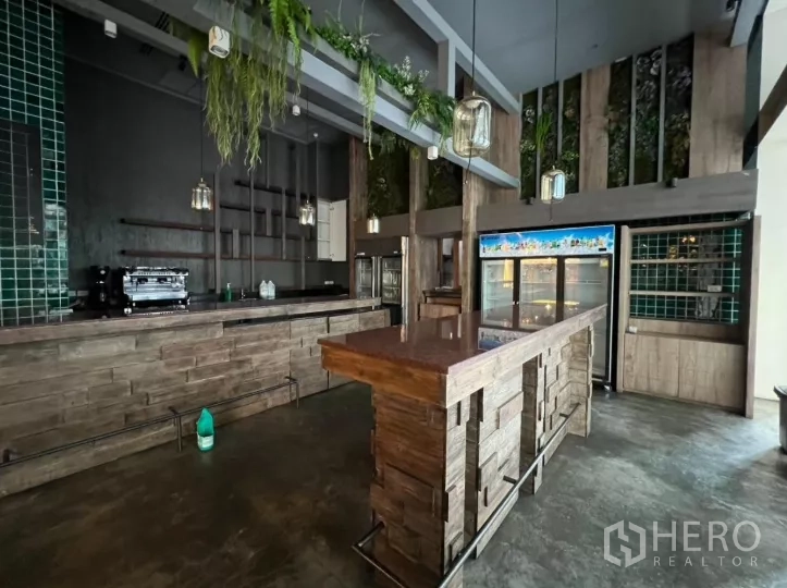 零售空间 出租 - 木质岛台吧，吊灯、冰柜与绿色瓷砖墙。