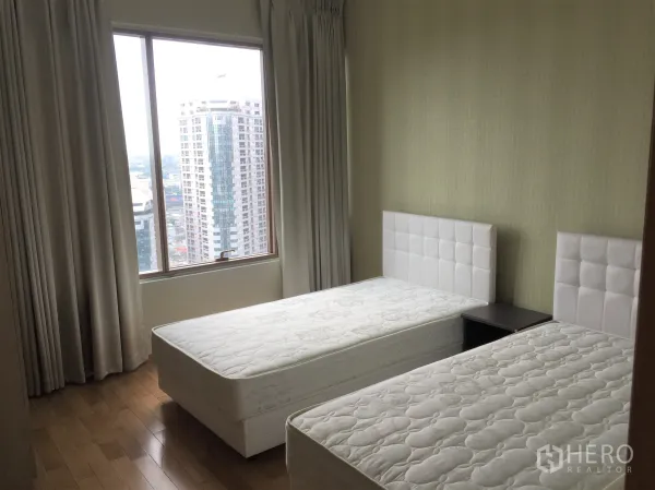 คอนโด ให้เช่าหรือขายในKhlong Toei, Bangkok - ห้องนอนเตียงคู่ มีหน้าต่างบานใหญ่เห็นวิวเมือง พื้นไม้และผ้าม่านโทนอ่อน