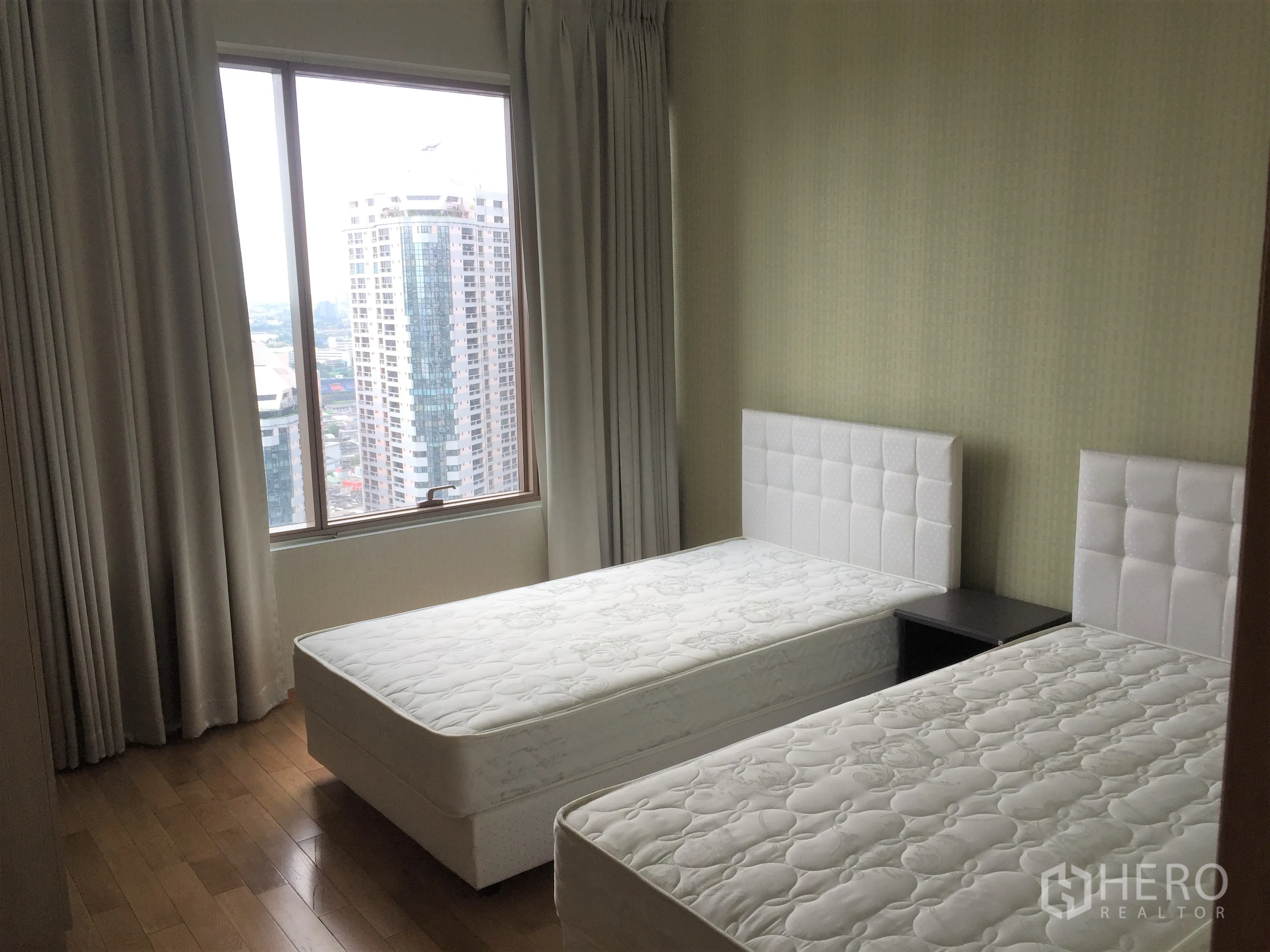 คอนโด ให้เช่าหรือขายในKhlong Toei, Bangkok - ห้องนอนเตียงคู่ มีหน้าต่างบานใหญ่เห็นวิวเมือง พื้นไม้และผ้าม่านโทนอ่อน