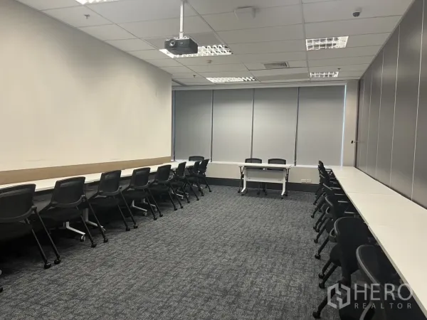 Office Space for rent in Huai Khwang, Bangkok - Training or seminar room with long desks on both sides, projector, carpet flooring and window blinds.