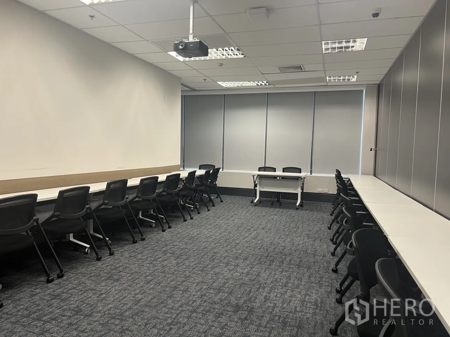 Office Space for rent in Huai Khwang, Bangkok - Training or seminar room with long desks on both sides, projector, carpet flooring and window blinds.