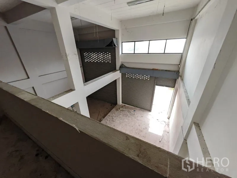 Home Office for rent or sale in Lam Luk Ka, Pathum Thani - View from mezzanine over loading area with roller shutter doors and clerestory windows.