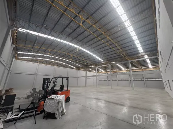 工厂 出租在Bang Phli, Samut Prakan - 高挑仓库内景，拱形屋顶与叉车，混凝土地面