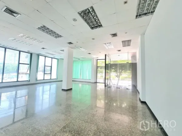 พื้นที่ขายปลีก ให้เช่าในSathon, Bangkok - มุมร้านสว่างพร้อมประตูกระจกทางเข้า เพดานไฟ และหน้าต่างสูงติดมู่ลี่สีเขียว