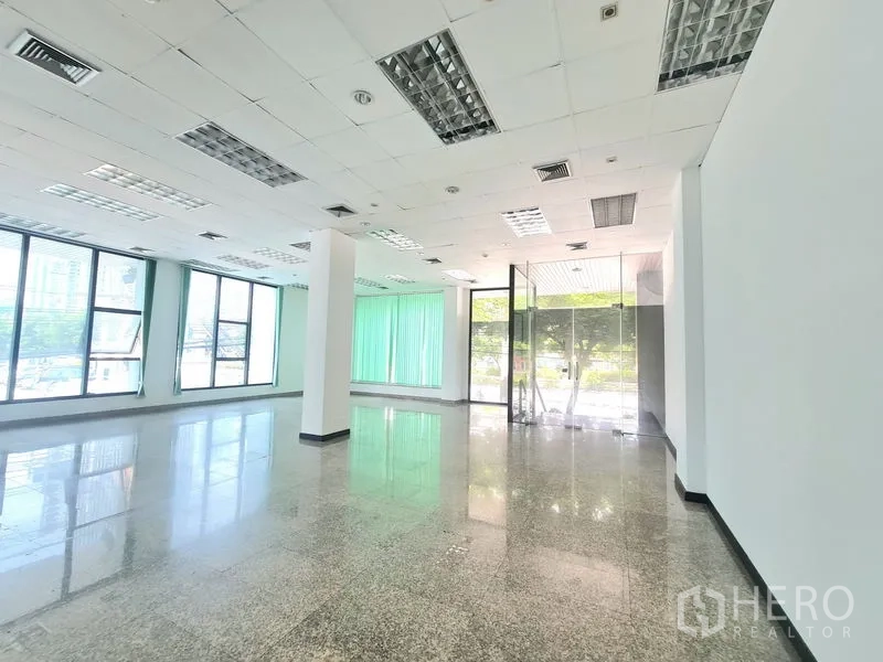 พื้นที่ขายปลีก ให้เช่าในSathon, Bangkok - มุมร้านสว่างพร้อมประตูกระจกทางเข้า เพดานไฟ และหน้าต่างสูงติดมู่ลี่สีเขียว