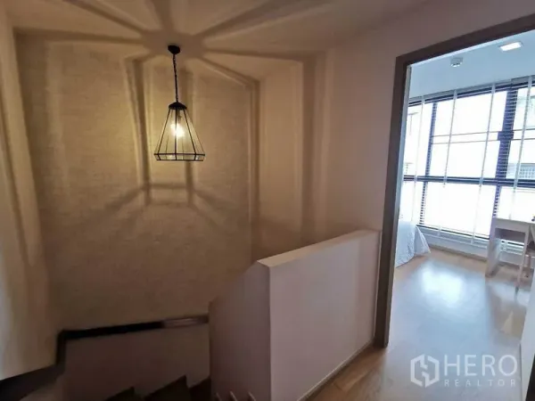 คอนโด ให้เช่าในWatthana, Bangkok - โถงบันไดพร้อมโคมไฟสไตล์ลอฟต์ เชื่อมสู่ห้องนอนสว่างที่มีหน้าต่างบานใหญ่