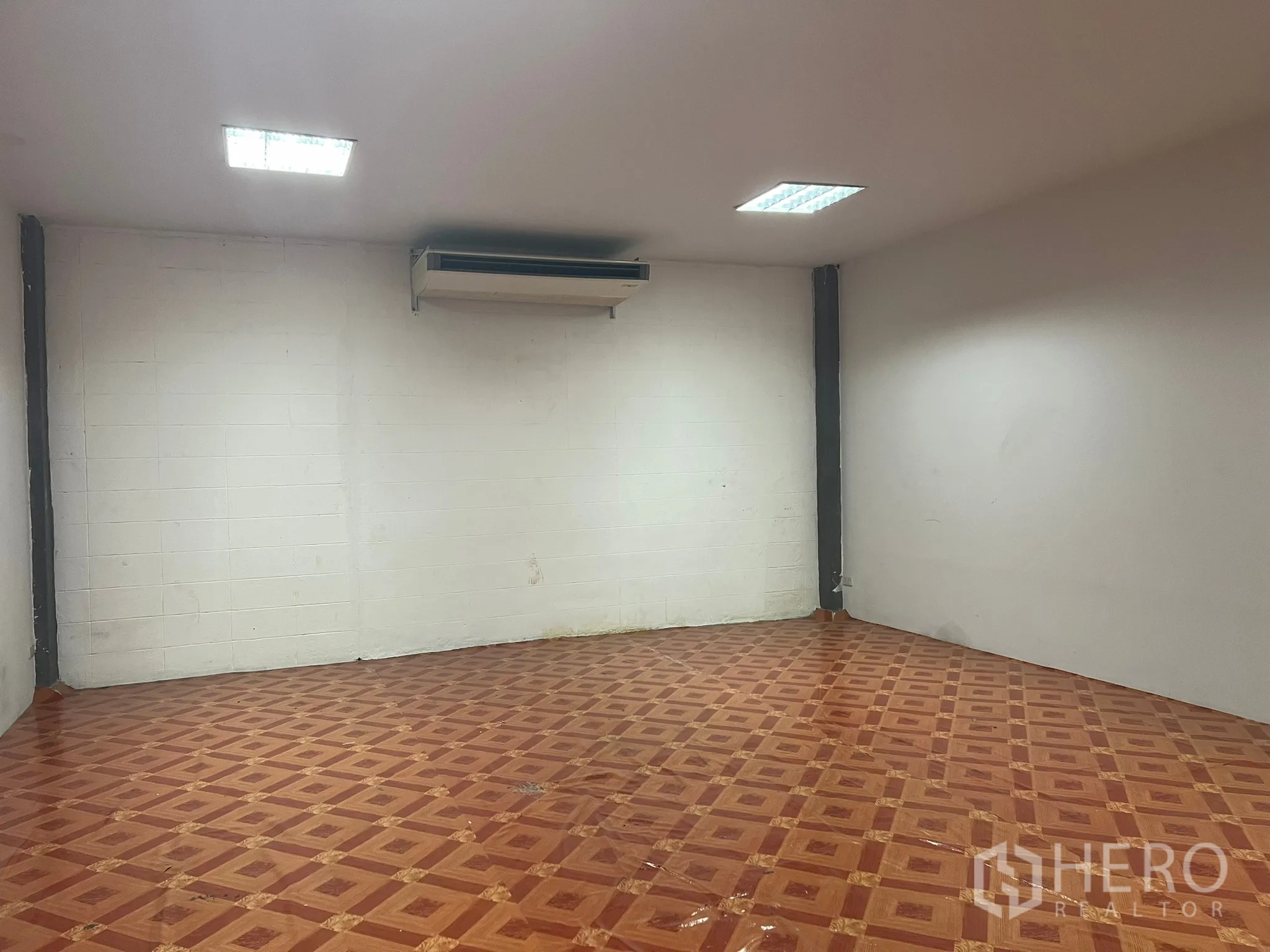 Factory for rent in Bang Pakong, Chachoengsao - Air-conditioned office room with white walls and patterned wooden-style floor tiles.