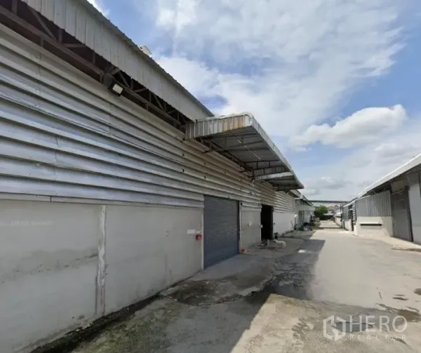 Warehouse for rent - Row of metal-clad warehouses with covered loading bays and a wide truck-friendly driveway.