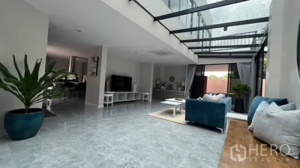 บ้าน ให้เช่าในLat Krabang, Bangkok - ห้องนั่งเล่นกว้าง หลังคากระจก ประตูบานเลื่อน พื้นกระเบื้องแวววาว โซฟาสีน้ำเงิน