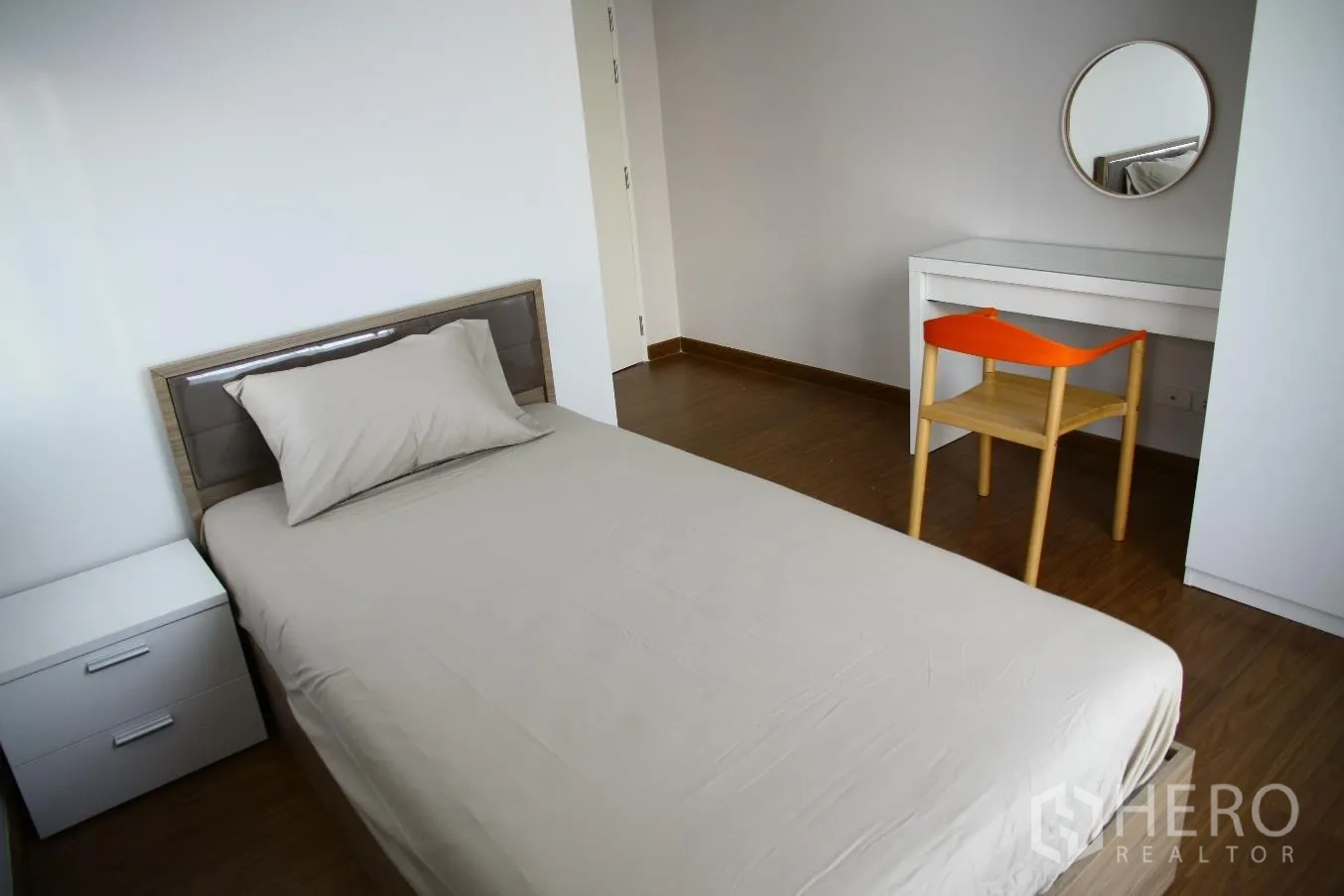 Detached House for rent or sale in Bang Na, Bangkok - Simple secondary bedroom with single bed, bedside table, study desk and mirror on wood floor.