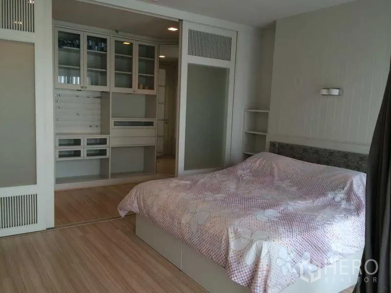 คอนโด ให้เช่าในKhlong Luang, Pathum Thani - ห้องนอนพร้อมตู้เสื้อผ้าบิลท์อิน ประตูบานเลื่อนกระจก พื้นไม้ และเตียงขนาดใหญ่โทนสีอบอุ่น