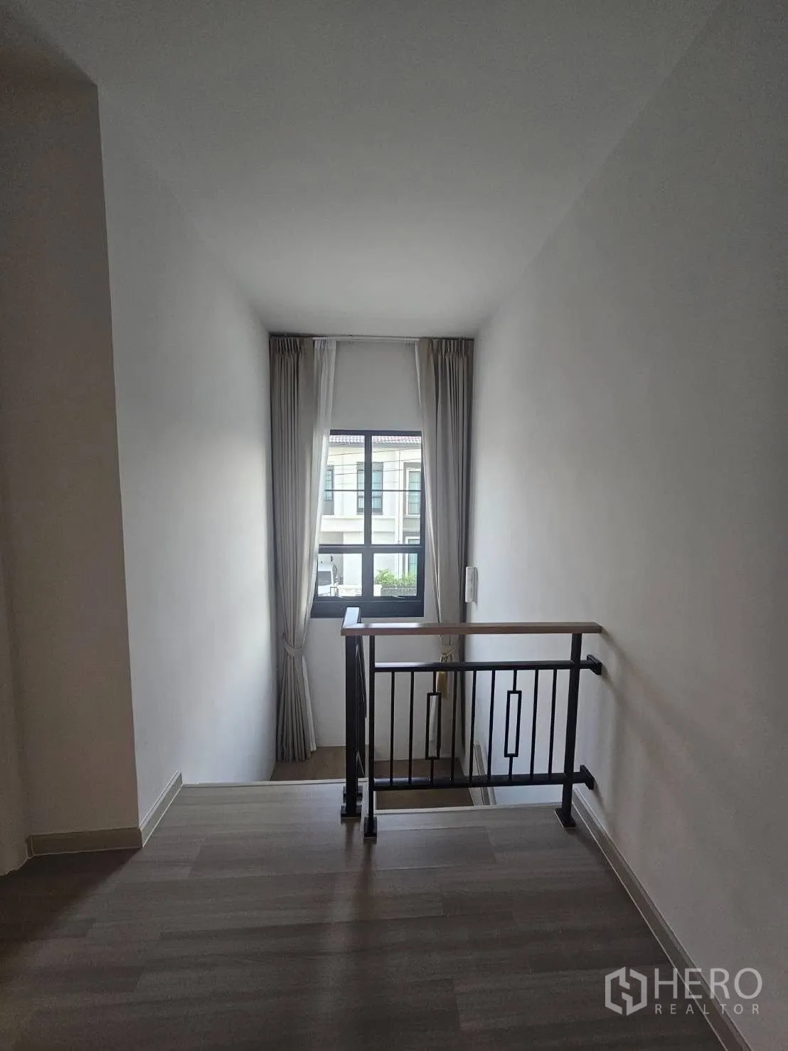 Detached House for rent in Khlong Sam Wa, Bangkok - Stairwell with metal handrail and natural light from a tall window.