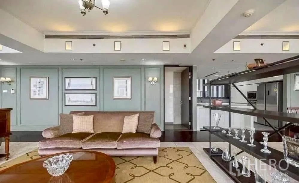 Condominium for rent in Sathon, Bangkok - Open-plan living room at The Met, Sathon with plush sofa, display shelving and adjoining modern kitchen.