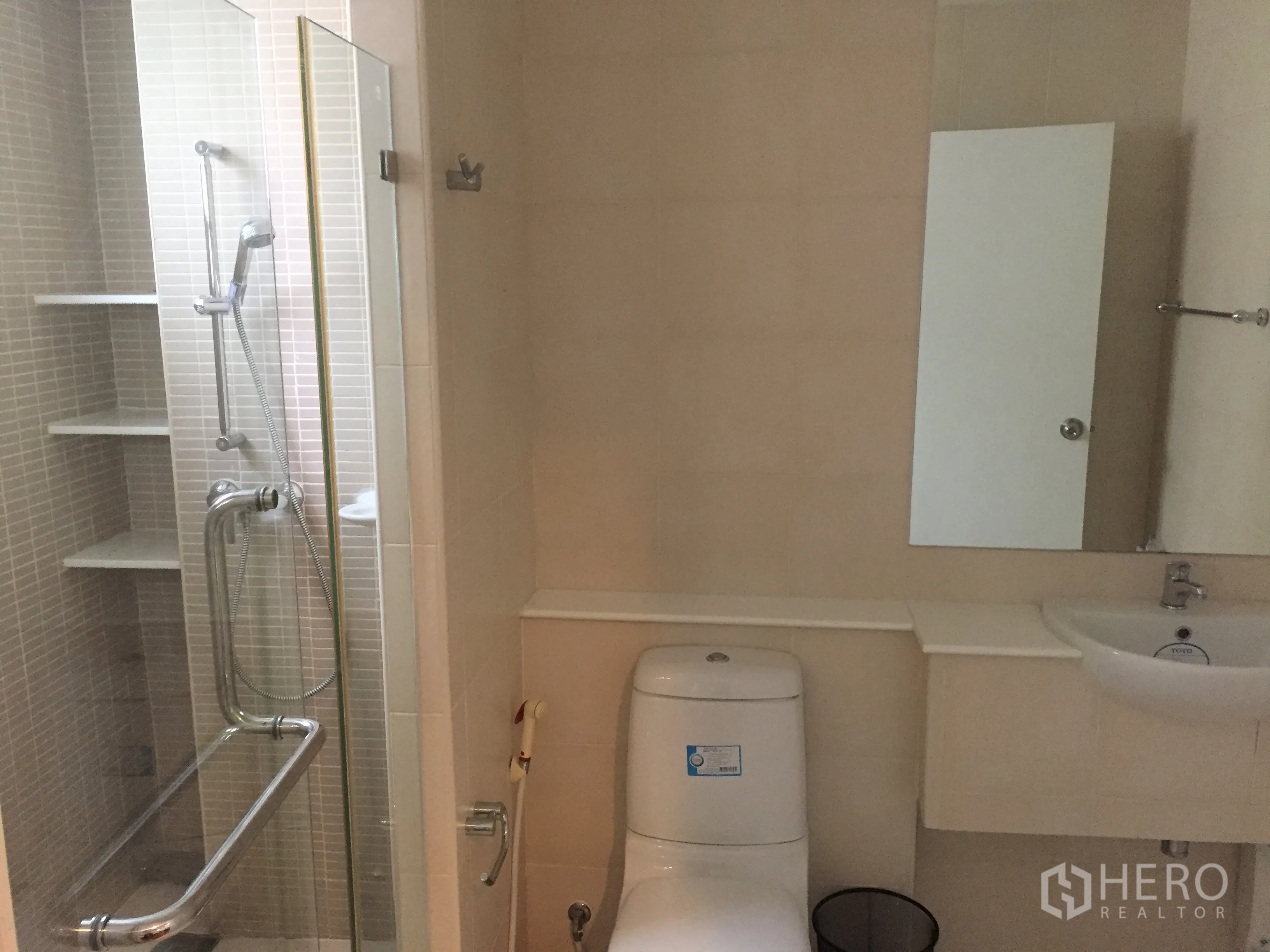Detached House for rent in Watthana, Bangkok - Modern bathroom featuring a glass-enclosed shower, toilet and compact vanity.
