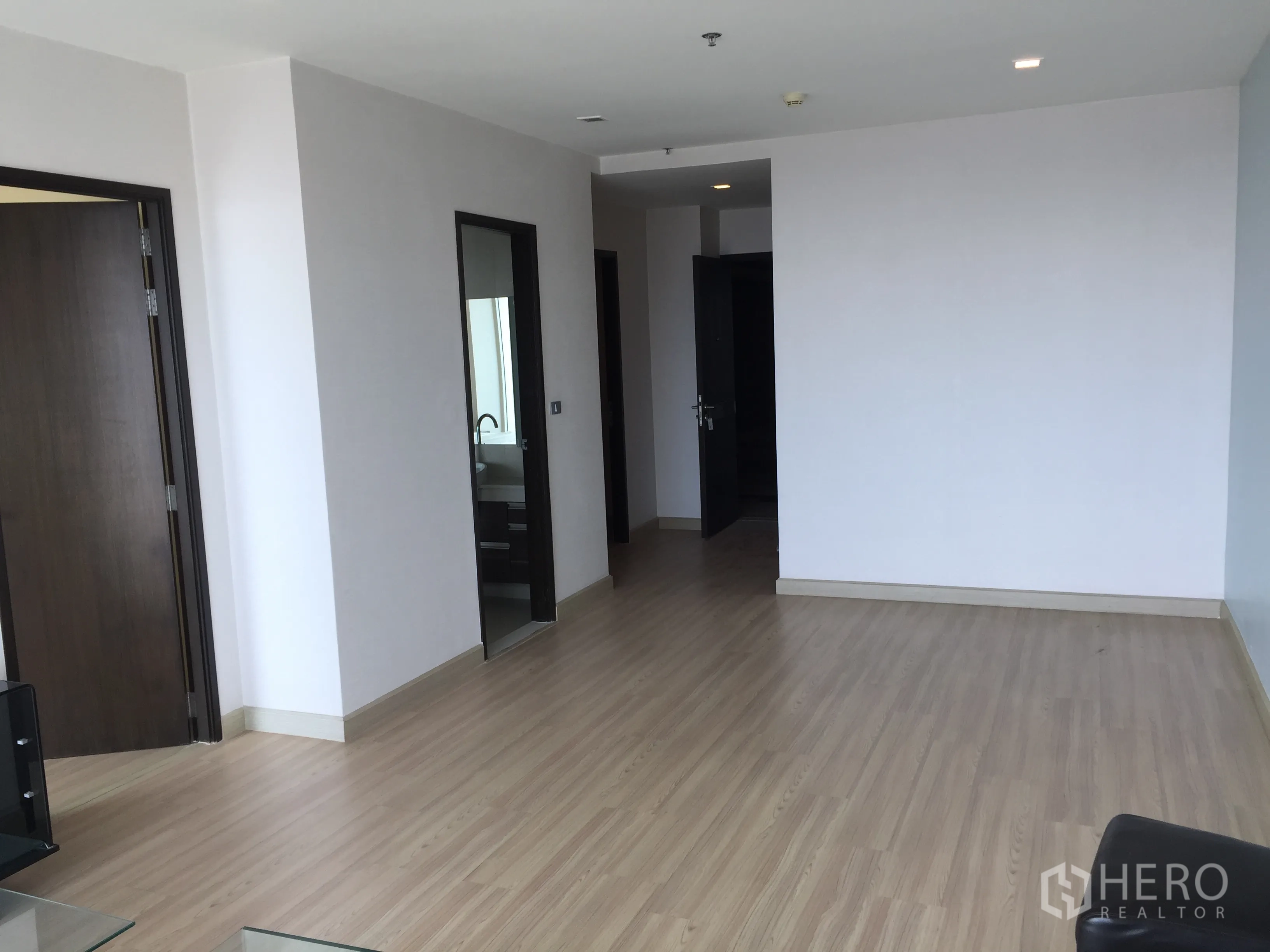 คอนโด ขายในWatthana, Bangkok - พื้นที่นั่งเล่นแบบเปิดโล่ง พื้นไม้โทนอ่อน เชื่อมต่อไปยังห้องนอนและห้องน้ำ