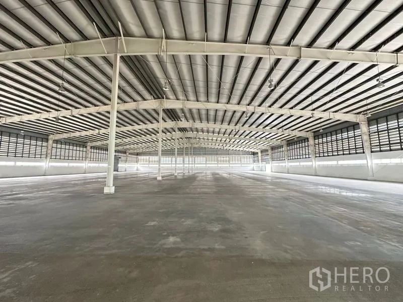 工厂 出租在Pathum Thani - 开放式生产大厅，挑高天花、通风百叶与照明。