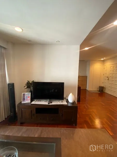 Condominium for rent in Pathum Wan, Bangkok - TV console in living area on warm wooden floors.