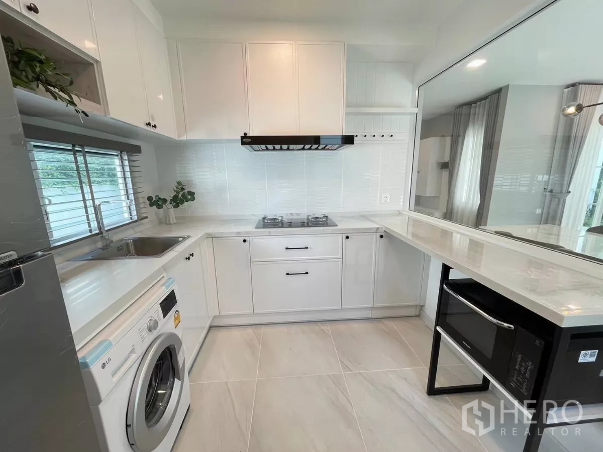 Detached House for rent in Bang Phli, Samut Prakan - Compact modern kitchen with pass-through counter, range hood, and white cabinetry.