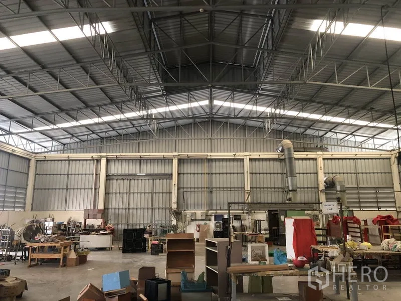 Factory for sale in Khlong Luang, Pathum Thani - Workshop area with machinery under ventilated metal wall panels and high roof.