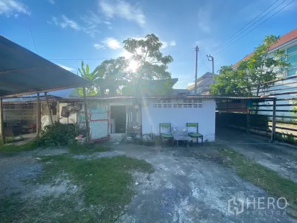 货栈 出租在Suan Luang, Bangkok - 院内附属小建筑与有顶储物区，开放院落，摆放椅子并有绿植。