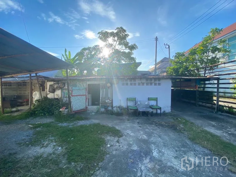 货栈 出租在Suan Luang, Bangkok - 院内附属小建筑与有顶储物区，开放院落，摆放椅子并有绿植。