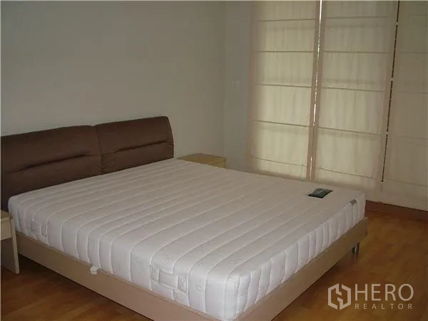 คอนโด ให้เช่าในKhlong Toei, Bangkok - ห้องนอนหลักเตียงคิงไซส์ พื้นไม้ และม่านบานม้วนเต็มความสูง