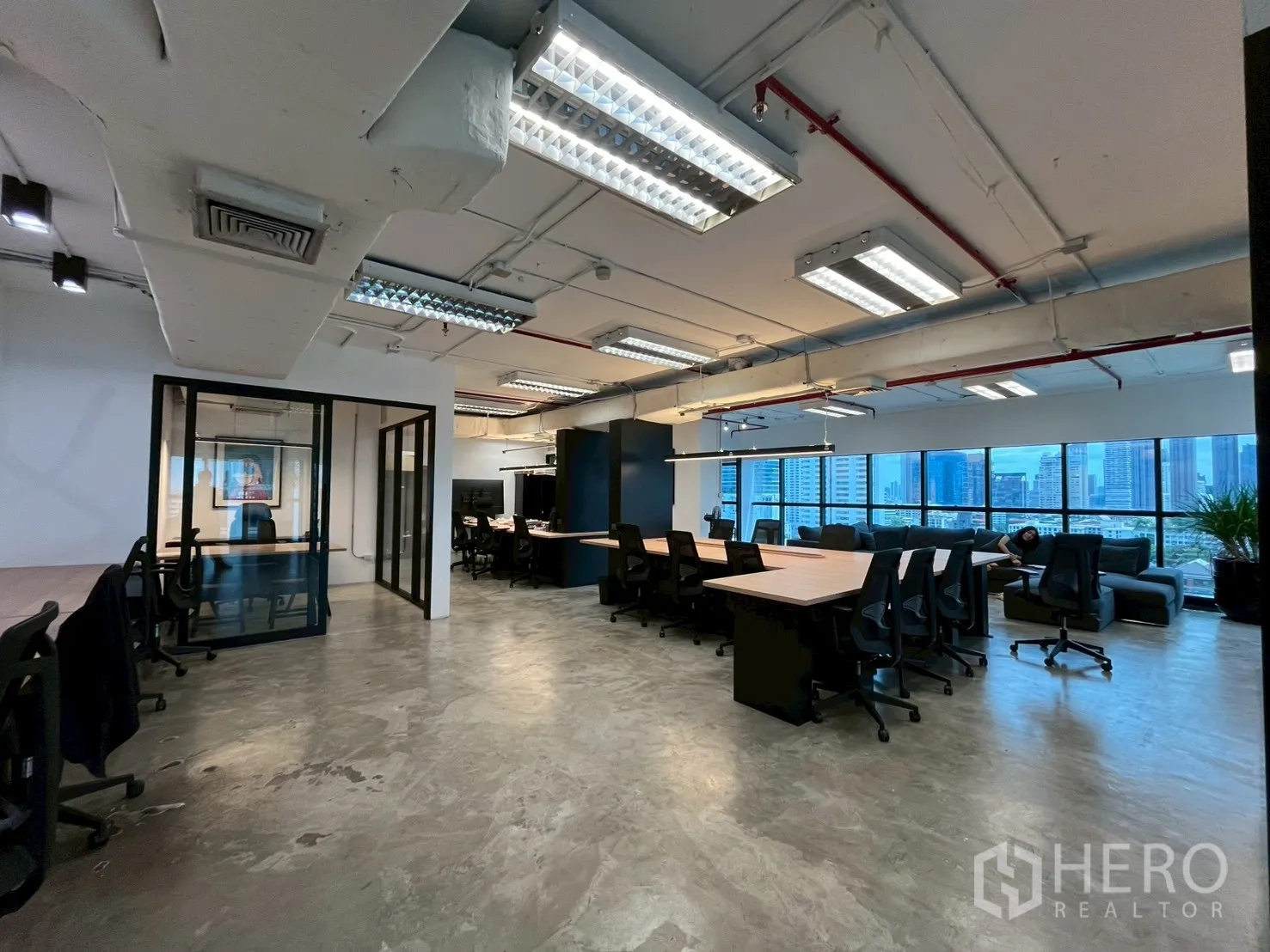 办公室 for rent in Watthana, Bangkok - 开放式办公区设长桌与玻璃会议室，落地窗带来城市景观。