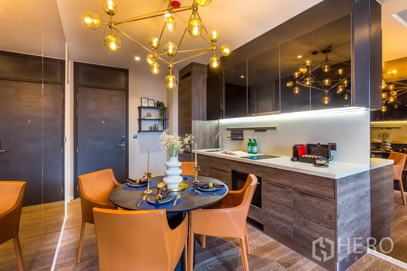 คอนโด ให้เช่าหรือขายในPathum Wan, Bangkok - มุมรับประทานอาหารพร้อมโคมไฟดีไซน์เนอร์ ข้างครัวเส้นตรงสุดทันสมัย ในคอนโดปทุมวัน