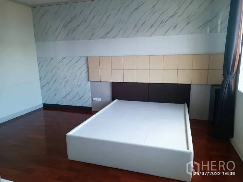 独立式住宅 出售在Prawet, Bangkok - 宽敞卧室，木地板，平台床架，装饰墙面与自然采光。