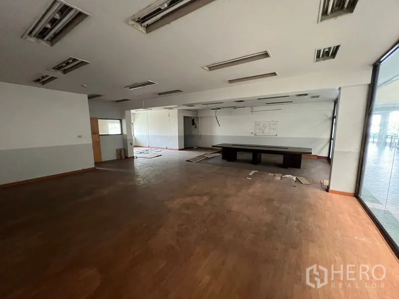 店屋 出租在Huai Khwang, Bangkok - 开放式办公区，大桌与整面高窗。