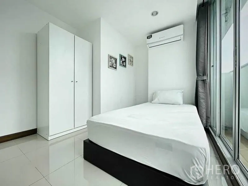 คอนโด ให้เช่าในKhlong Toei, Bangkok - อีกมุมของห้องนอนเดี่ยวพร้อมตู้เสื้อผ้าสีขาวและประตูกระจกบานเลื่อน