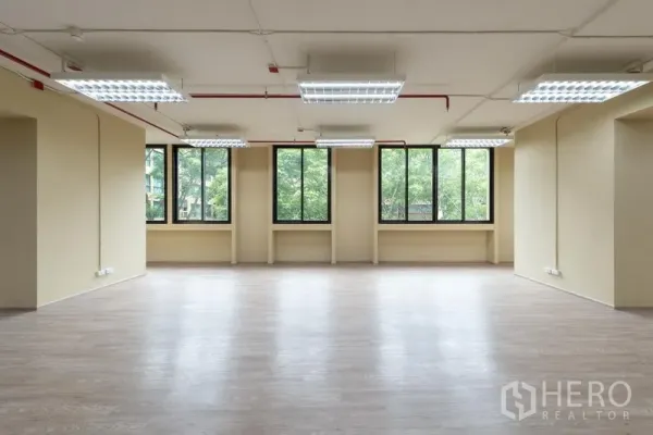 办公空间 出租在Chatuchak, Bangkok - 明亮工作区，整排高窗与中性色墙面，可见树景，适合出租办公。