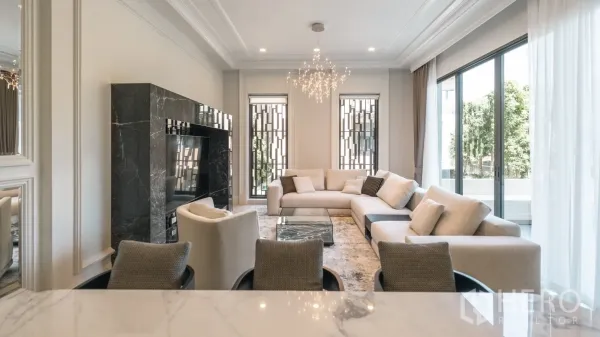 บ้าน ให้เช่าหรือขายในBang Kapi, Bangkok - ห้องนั่งเล่นสว่าง โซฟา L ผนังทีวีหินอ่อน หน้าต่างบานใหญ่ และโคมระย้า