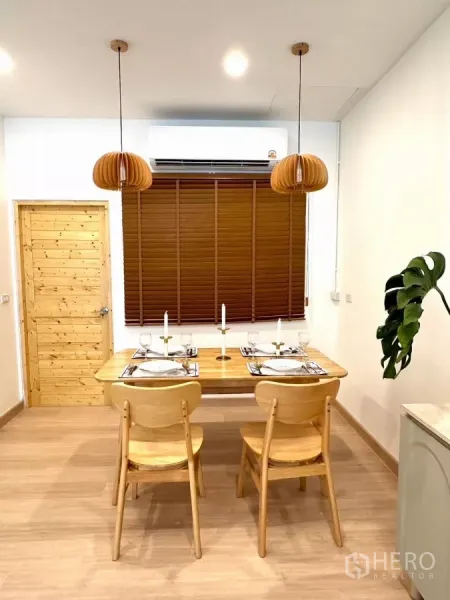 ทาวน์เฮาส์ ให้เช่าในBang Phli, Samut Prakan - มุมรับประทานอาหารสำหรับ 4 ที่นั่ง ใต้โคมไฟแขวนและมู่ลี่ไม้