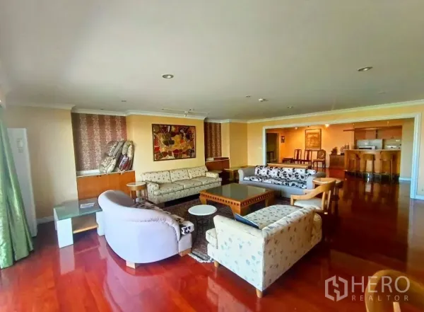 คอนโด ให้เช่าในWatthana, Bangkok - มุมมองกว้างของโซนรับแขก พื้นไม้ขัดเงา โซฟาล้อมโต๊ะกลาง เชื่อมต่อบาร์และพื้นที่รับประทานอาหาร