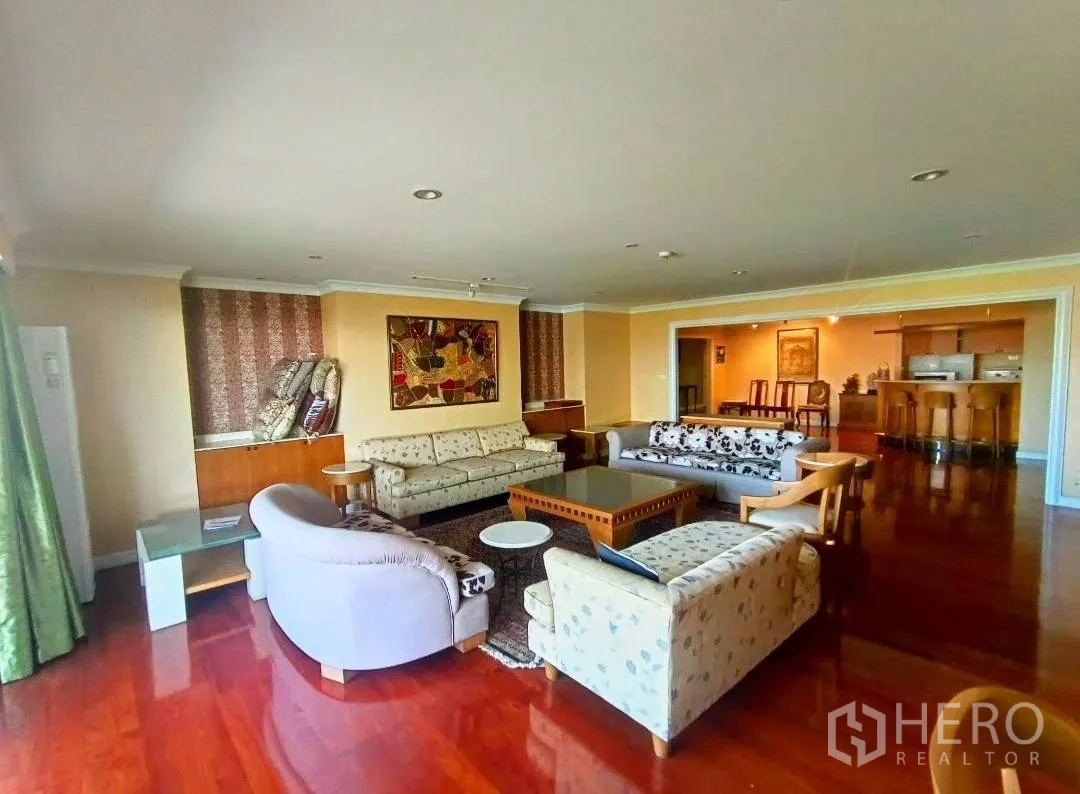 คอนโด ให้เช่าในWatthana, Bangkok - มุมมองกว้างของโซนรับแขก พื้นไม้ขัดเงา โซฟาล้อมโต๊ะกลาง เชื่อมต่อบาร์และพื้นที่รับประทานอาหาร