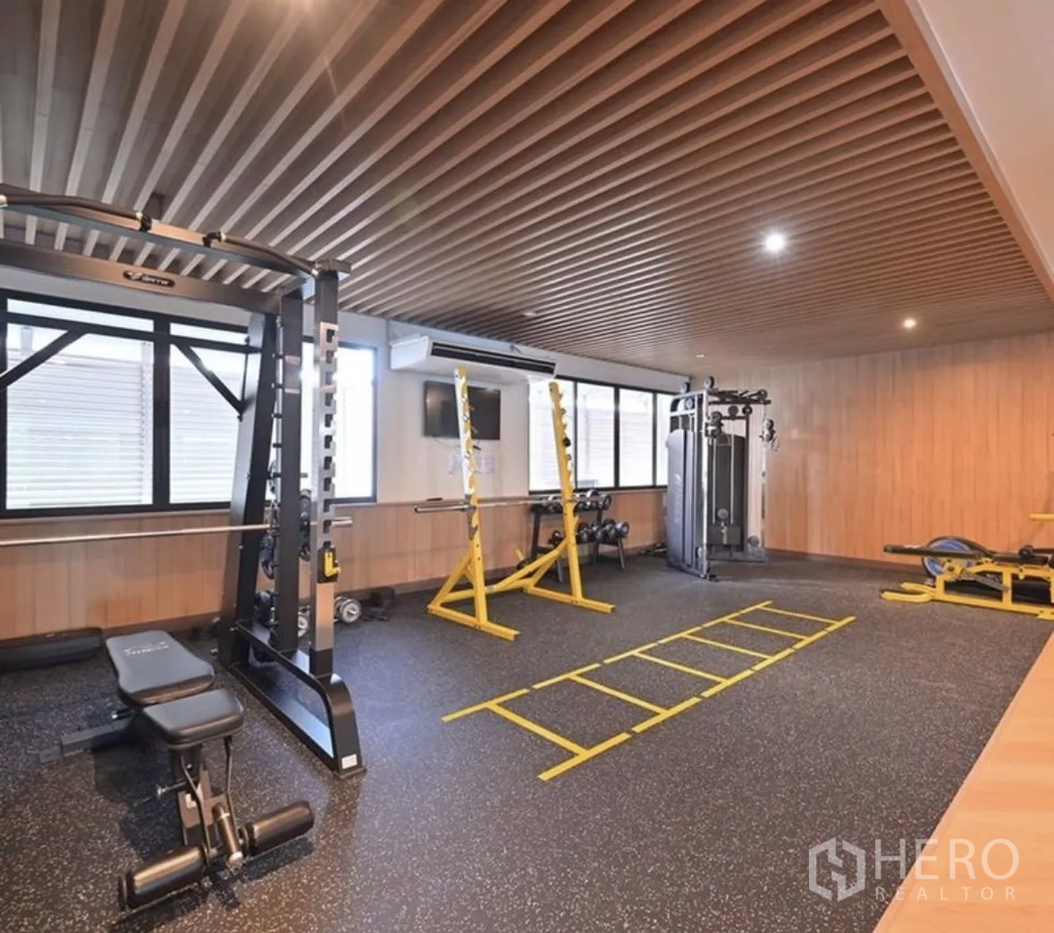 Condominium for rent or sale in Watthana, Bangkok - Condo fitness room with free weights, squat rack, and training equipment.