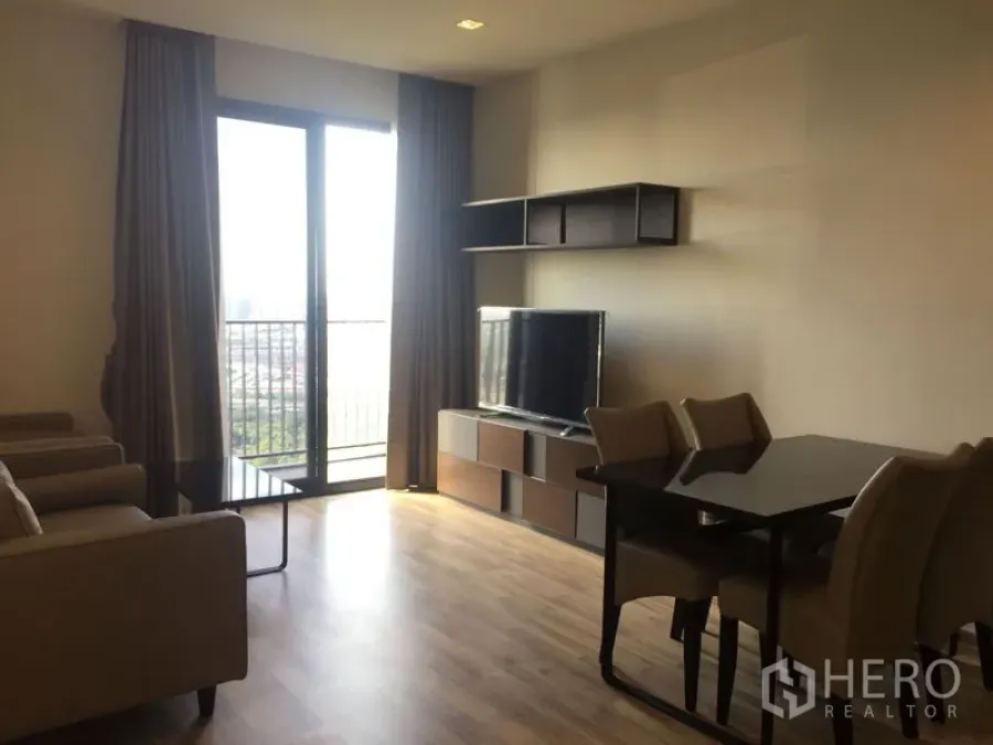 Condominium for rent in Chatuchak, Bangkok - Bright living room with TV unit, dining set and balcony offering city views.