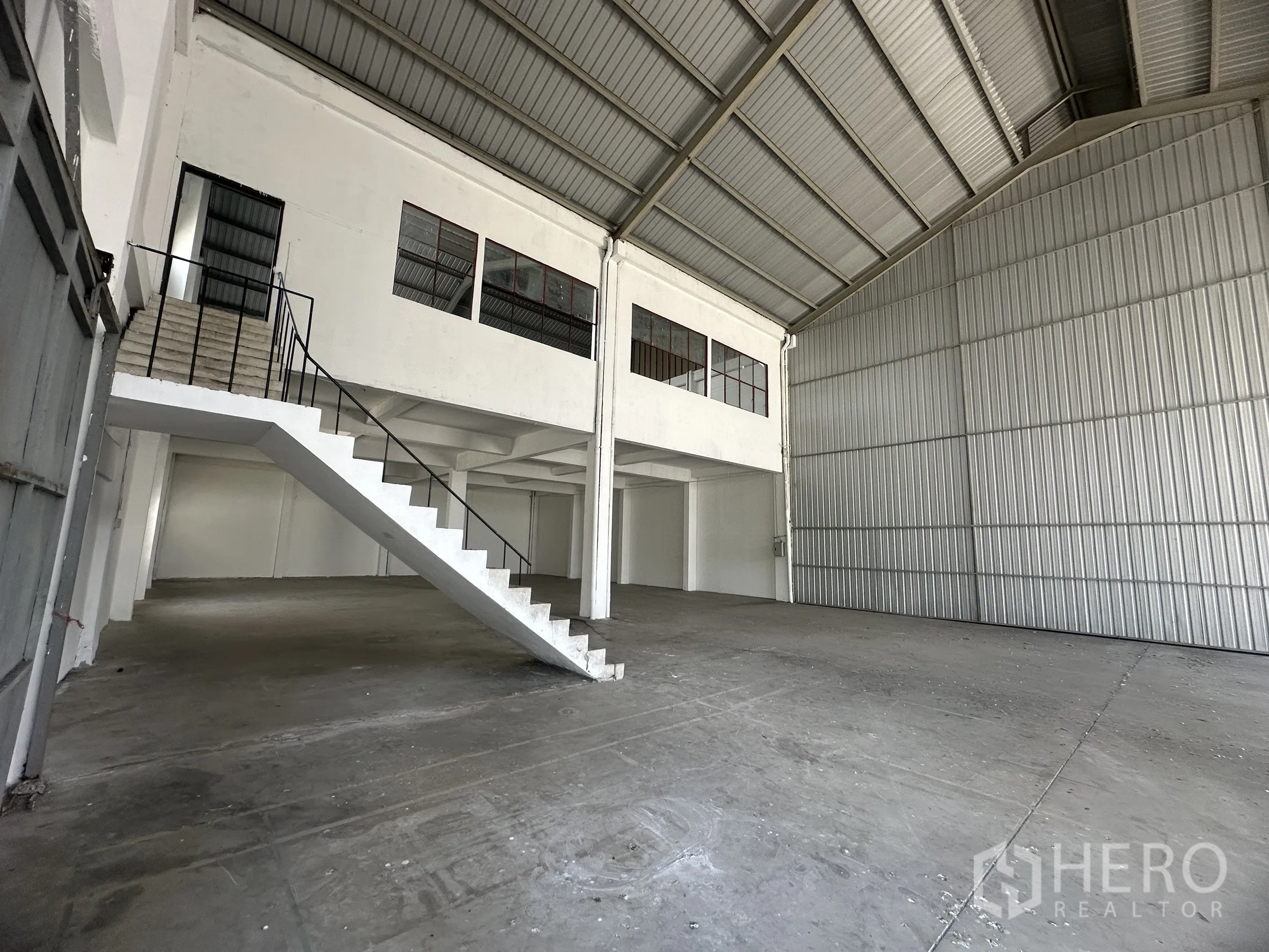 Factory for rent in Mueang Samut Prakan, Samut Prakan - Mezzanine office with windows and a metal staircase inside the open production area.