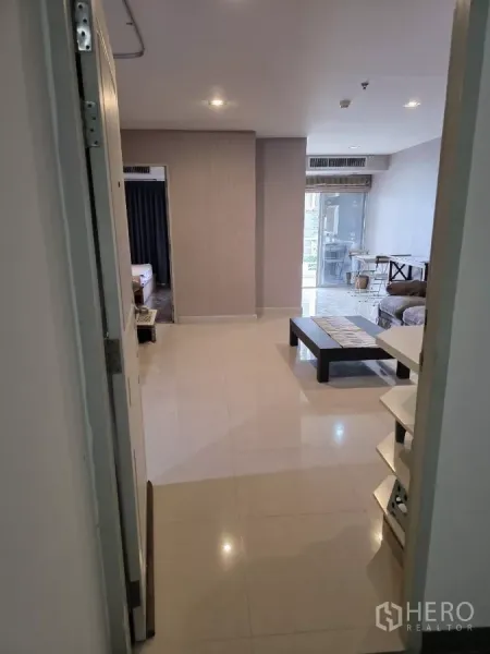 คอนโด ให้เช่าในKhlong Toei, Bangkok - มุมมองจากทางเข้าถึงห้องนั่งเล่นพื้นกระเบื้องเงา เห็นประตูห้องนอนและระเบียง คอนโด 1 ห้องนอนใกล้บีทีเอสพร้อมพงษ์