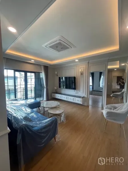 Detached House for rent in Bang Phli, Samut Prakan - Upstairs family lounge with wood floors, wall-mounted TV and doors to a balcony.