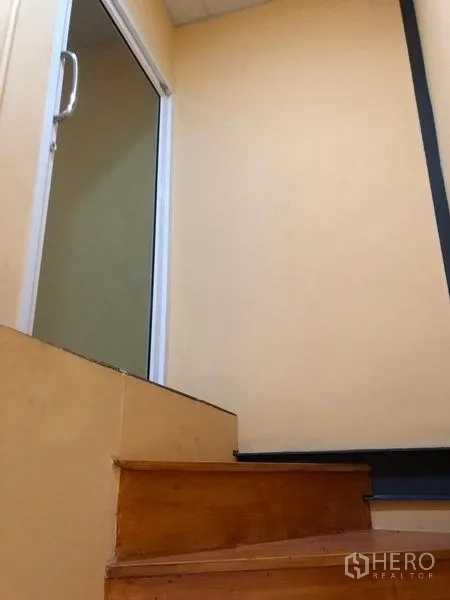 Warehouse for rent in Pak Kret, Nonthaburi - Staircase leading to the mezzanine office with a glass entry door.