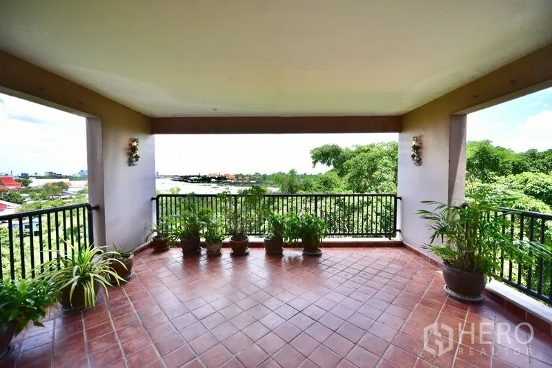 คอนโด ขายในPak Kret, Nonthaburi - ระเบียงกว้างปูกระเบื้องดินเผา มีต้นไม้กระถางและวิวสีเขียวโล่ง