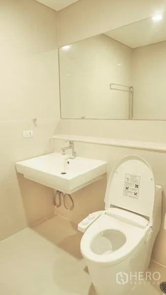 公寓 出租在Watthana, Bangkok - 干净浴室，坐便器、大镜子与紧凑台盆