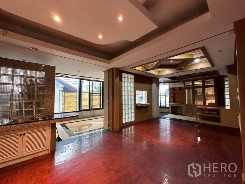 ทาวน์เฮาส์ ให้เช่าในKhlong Toei, Bangkok - ห้องนั่งเล่นครอบครัวกว้าง มีซิงก์แพนทรี ผนังบล็อกแก้ว และพื้นปาร์เกต์