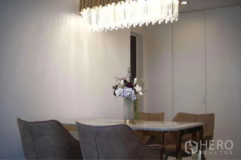 Condominium for rent in Sathon, Bangkok - Elegant dining area with crystal chandelier, marble-top table and upholstered chairs.