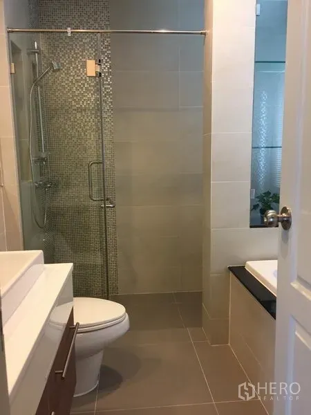 Detached House for rent or sale in Saphan Sung, Bangkok - Contemporary bathroom with glass shower enclosure and mosaic accent tiles.