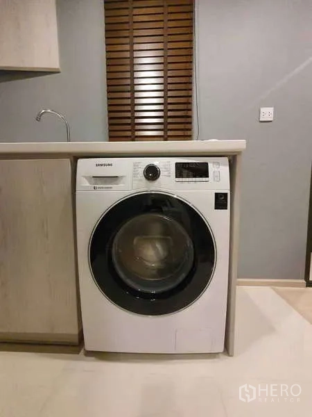 Condominium for rent - Front-loading Samsung washing machine integrated under the kitchen counter.