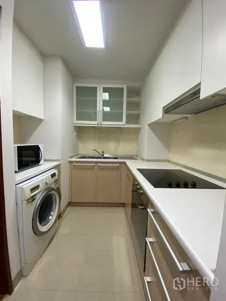 คอนโด ให้เช่าหรือขายในKhlong Toei, Bangkok - ครัวแบบแกลเลย์พร้อมเตาไฟฟ้า เตาอบ เครื่องซักผ้า และไมโครเวฟ